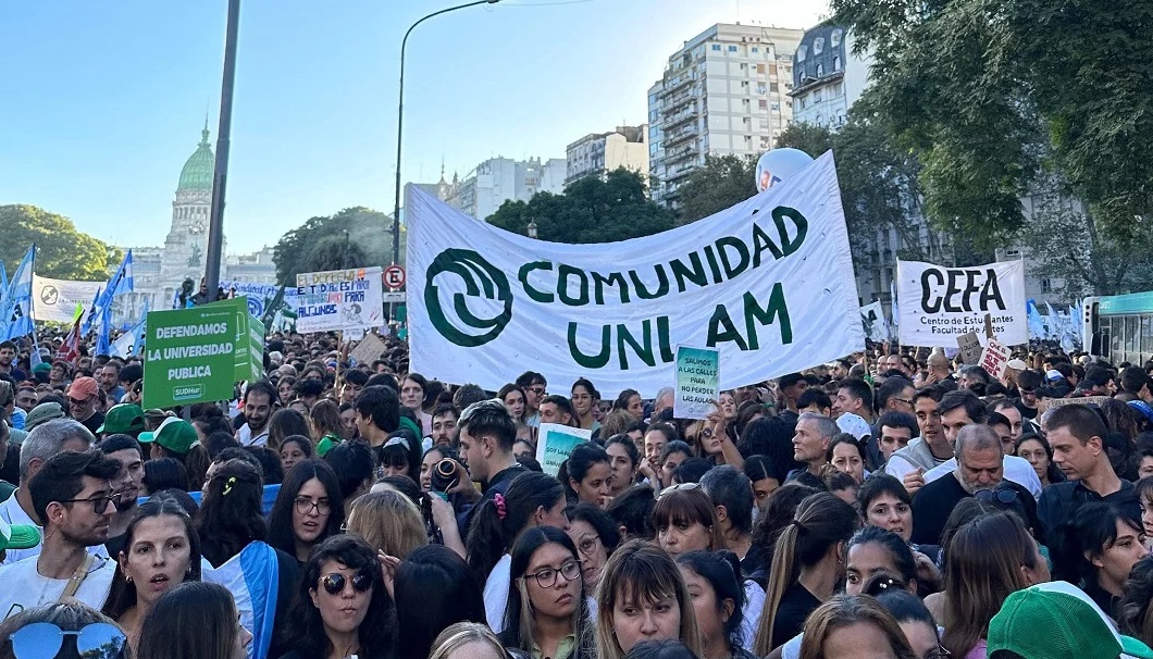 Estudiantes y docentes marchando con carteles por la universidad pública