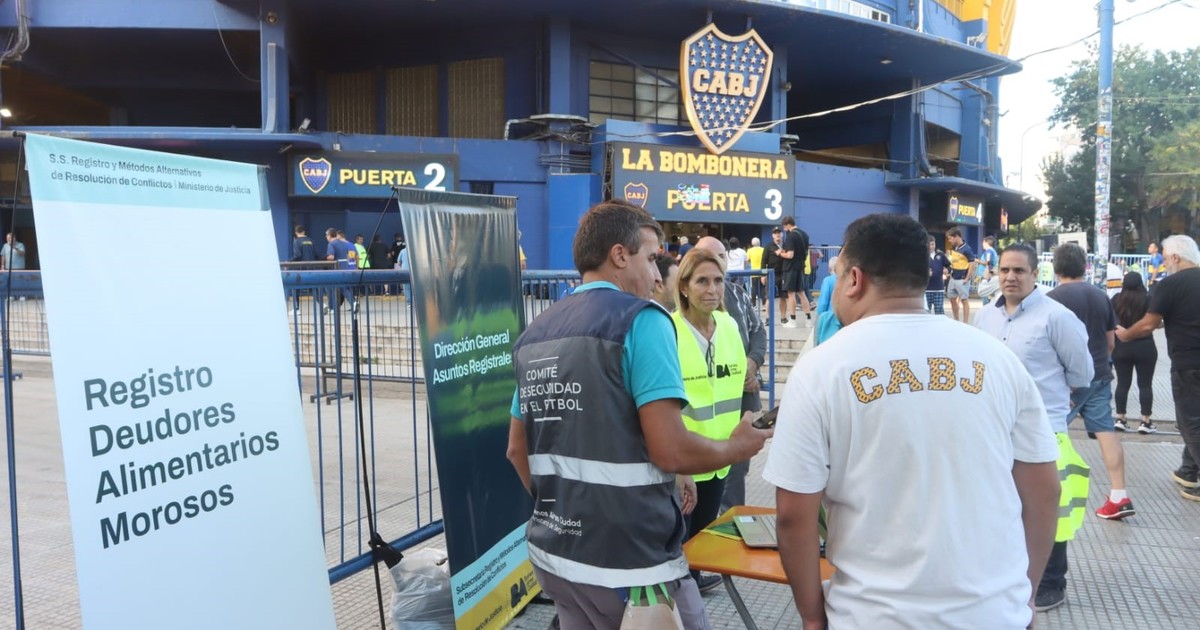 Personas ingresando a un estadio de fútbol con control de acceso