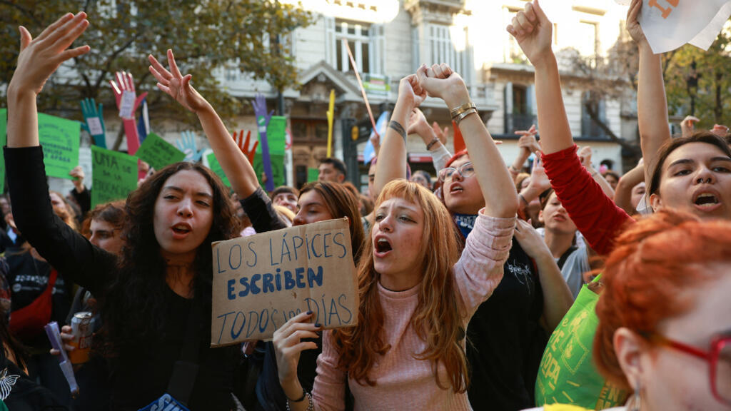manifestantes con carteles en una marcha universitaria en Buenos Aires