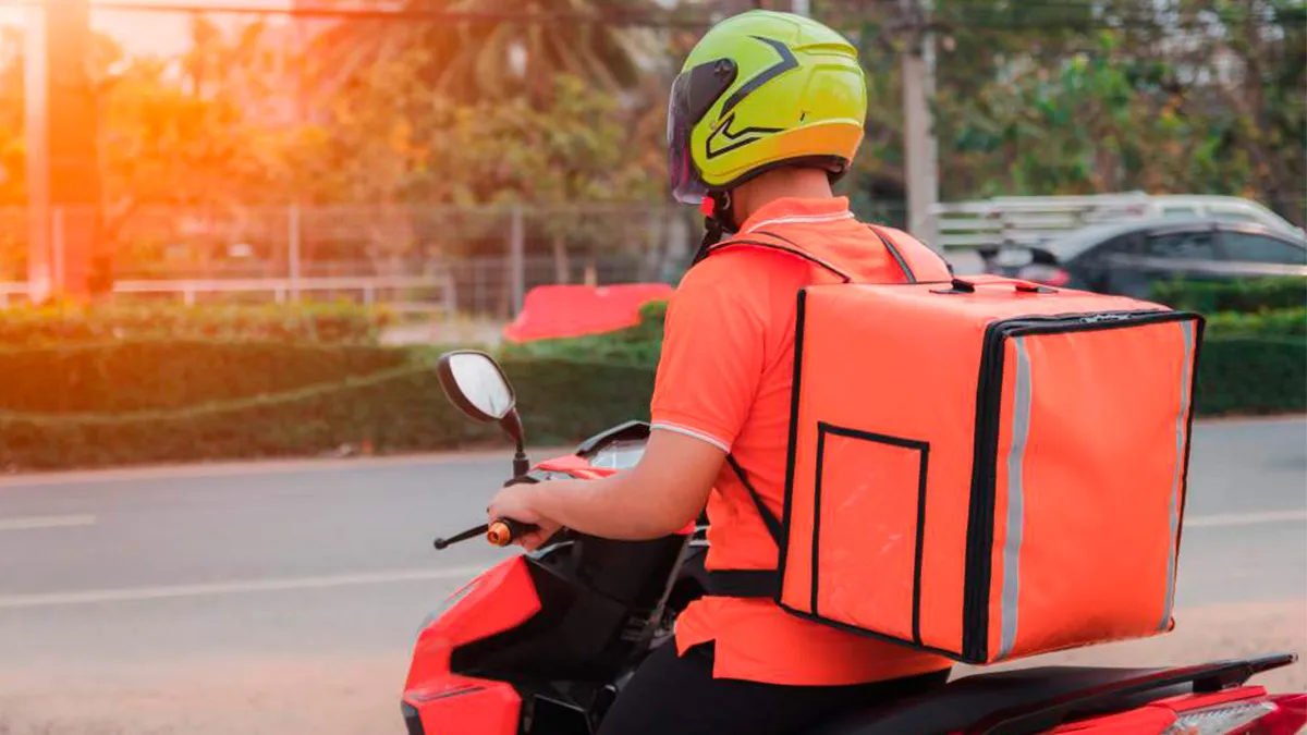 Repartidor en bicicleta con mochila de delivery en la calle