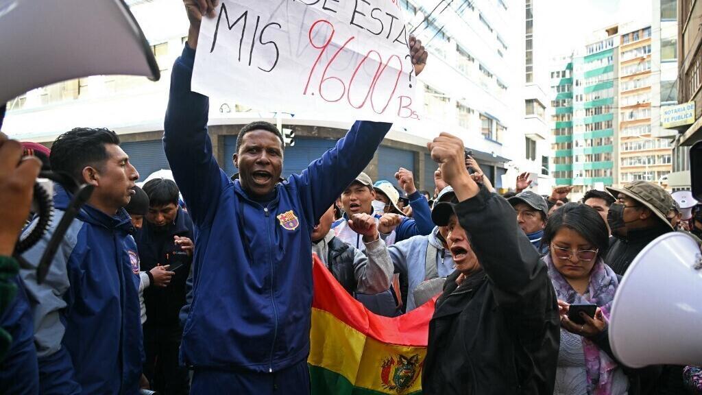 Manifestantes bloquean una calle en La Paz, Bolivia, con carteles de protesta