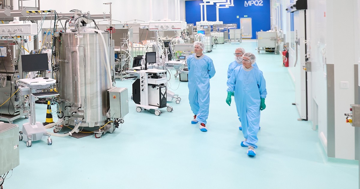 Interior de una planta de vacunas reconfigurable con robots y pantallas de monitoreo