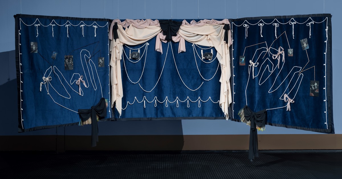 Instalación artística con máscaras y objetos en sala de exposición