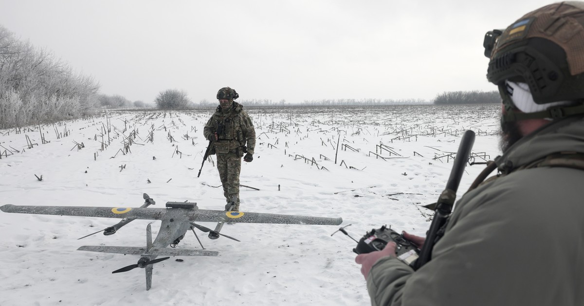 Soldado ucraniano usando un poncho de camuflaje en el campo de batalla