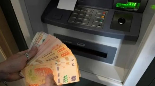 billetes de pesos argentinos y calculadora sobre una mesa