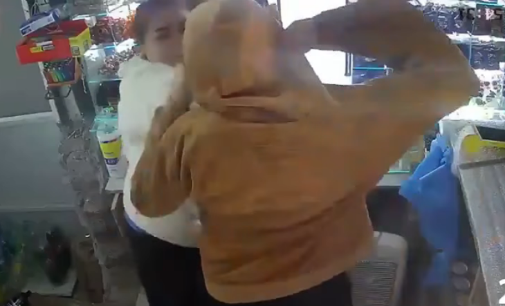 Cámara de seguridad muestra a un delincuente encapuchado saltando el mostrador de un kiosco