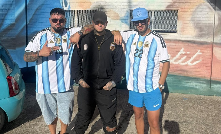 Integrantes de Ruido Piola posando con la bandera argentina