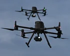 Niños miran un dron sobre un campo de fútbol en el sur de Colombia