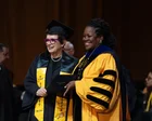 Billie Jean King sonriendo con birrete y toga de graduación