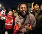 Hinchas del Arsenal celebrando frente al Emirates Stadium