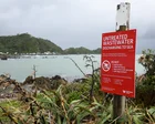 Vista de la costa de Wellington con cartel de advertencia por contaminación