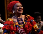Totó la Momposina cantando en un escenario con vestimenta tradicional