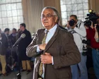 Barney Frank sonriendo frente a un micrófono en una conferencia de prensa