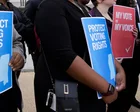 Multitud reunida frente al War Memorial Building en Jackson, Misisipi, con carteles de protesta