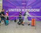 Personas caminando por una calle de Londres con banderas británicas