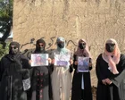 Niñas afganas con burka caminando por una calle polvorienta