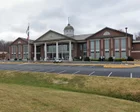 Reunión de junta escolar en Tennessee con asistentes sentados en filas