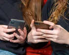 Adolescentes usando teléfonos móviles en un espacio público