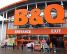 Fachada de una tienda B&Q con productos de jardinería en el exterior