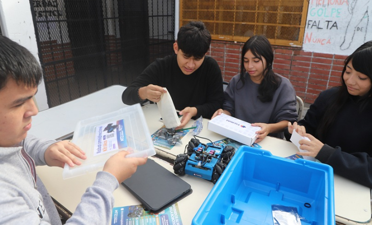 Estudiantes manipulando kits de robótica en un aula