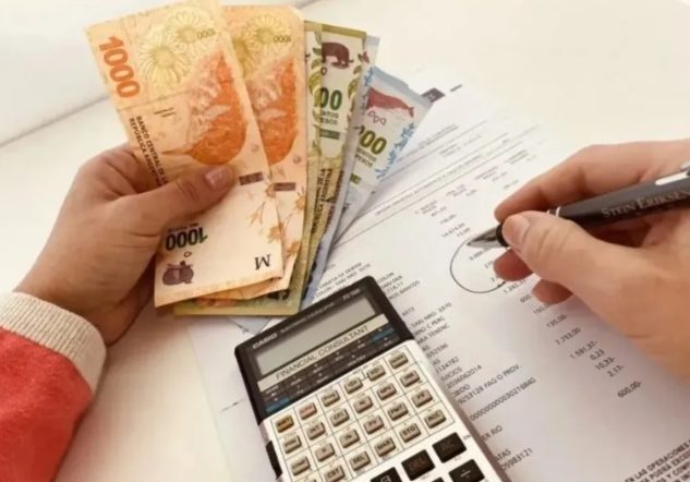 Calculadora y billetes de pesos argentinos sobre una mesa