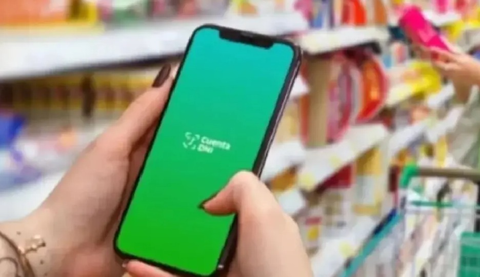 Persona usando celular con la app Cuenta DNI en un supermercado
