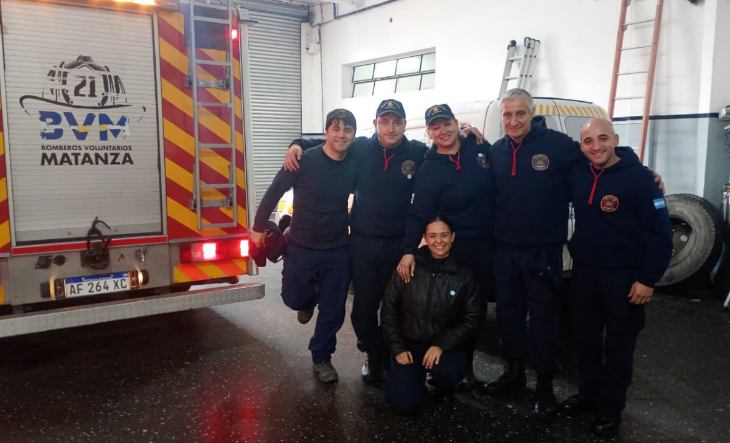 Bomberos voluntarios en formación frente a un cuartel