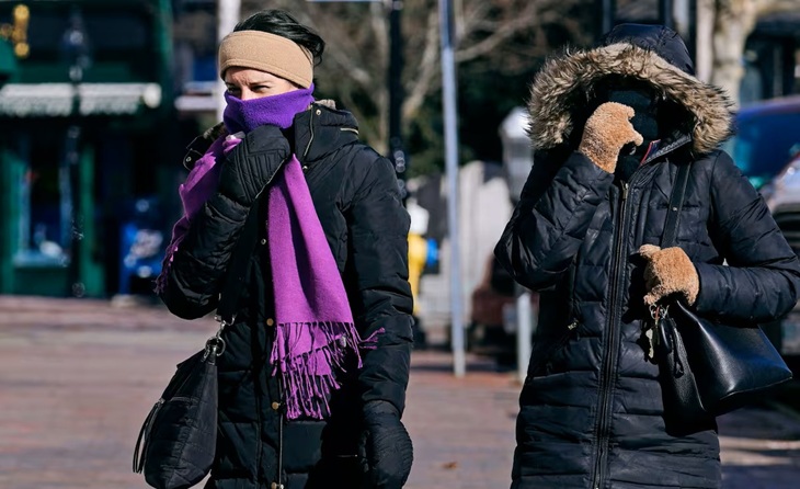 Personas abrigadas caminando en la calle durante un día frío