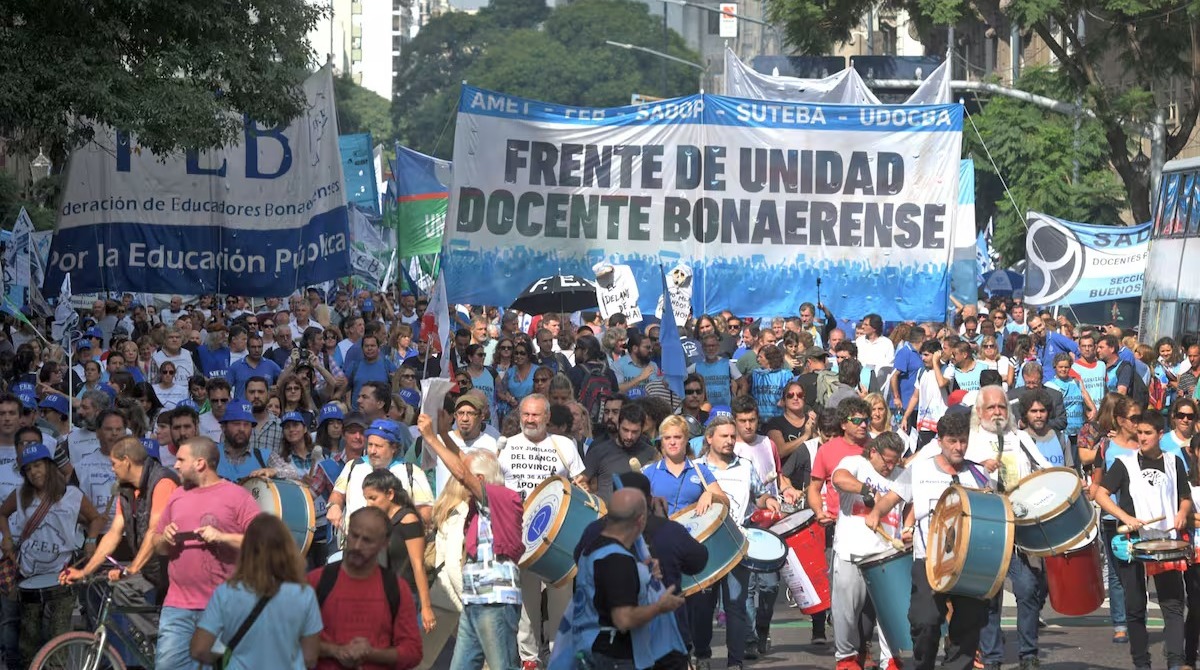 Docentes en una asamblea frente a una escuela
