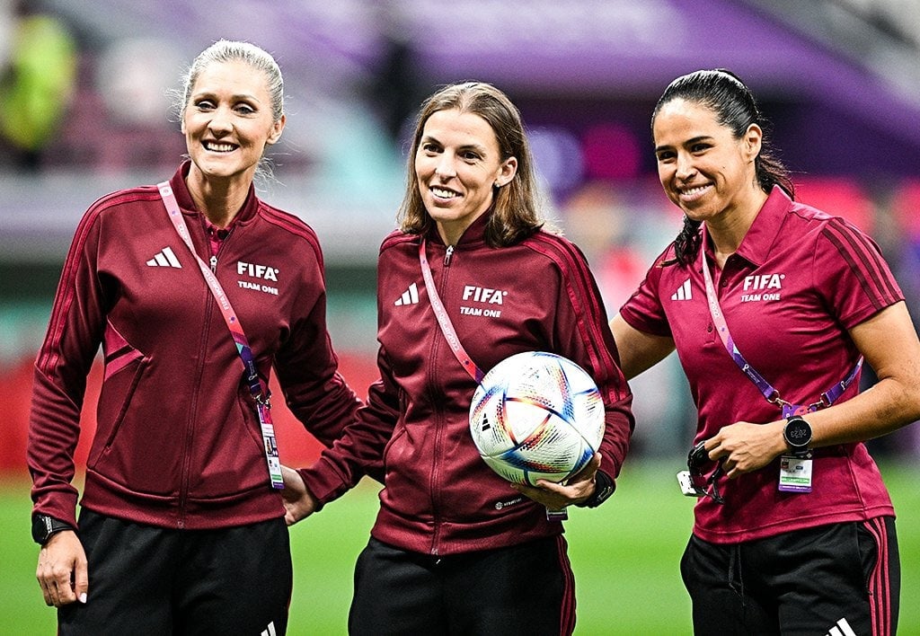 Árbitra femenina con silbato en un campo de fútbol durante un partido del Mundial