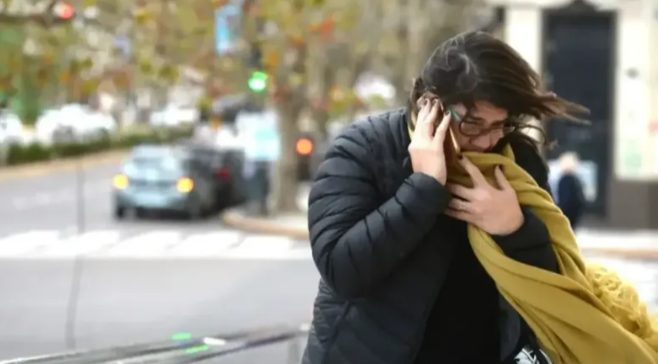 Personas abrigadas caminan por la calle en un día de invierno