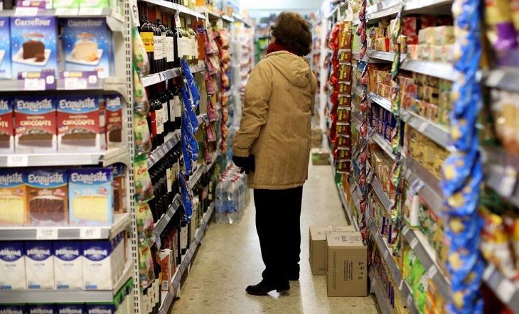 Persona mayor pagando con tarjeta de débito en un comercio