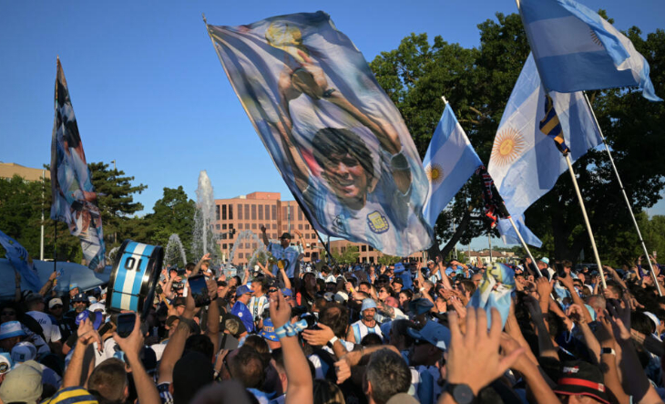 Personas reunidas viendo un partido de fútbol en una pantalla gigante