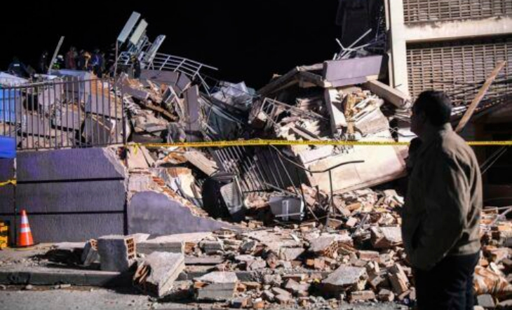 Personas revisando escombros tras un terremoto en zona urbana