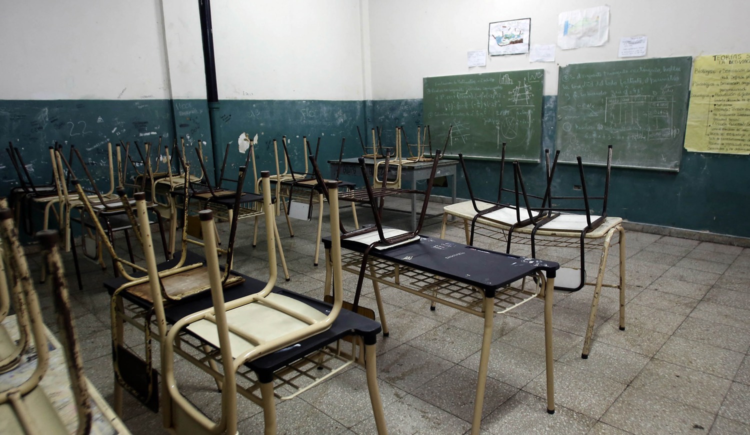 Docentes con carteles de reclamo frente a una escuela