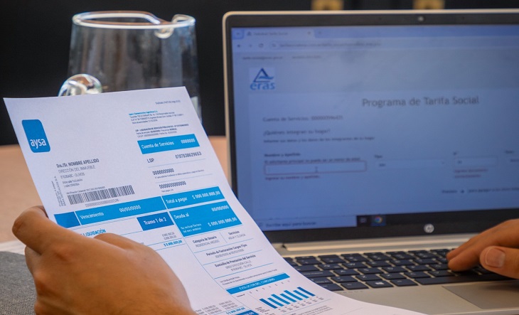 Factura de AySA y manos llenando un formulario web