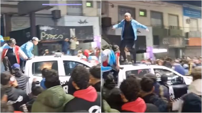 Personas sobre un patrullero en medio de una multitud en una plaza