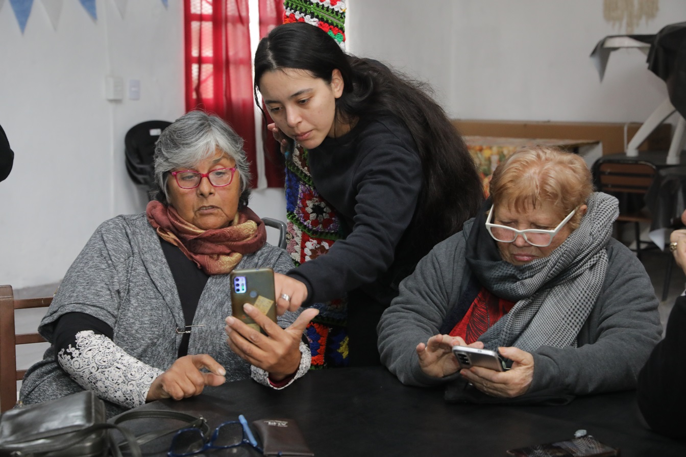 Adultos mayores usando celulares en un taller comunitario