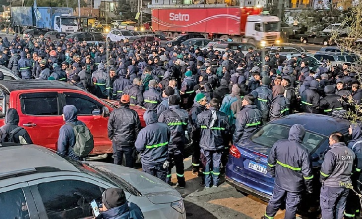 Trabajadores frente a una distribuidora cerrada en Tapiales