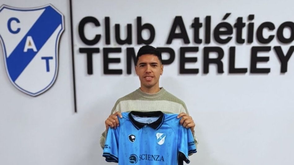 Jugador de fútbol con camiseta celeste posando en un estadio