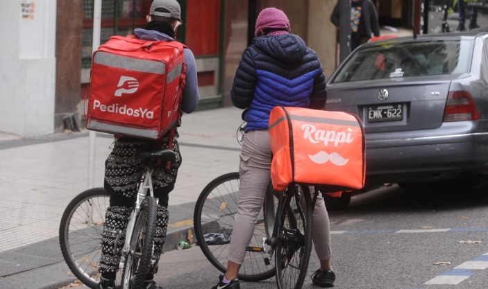 Repartidor en bicicleta con mochila de delivery en la calle
