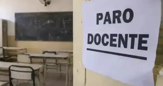 Docentes en una asamblea sindical con carteles de reclamo