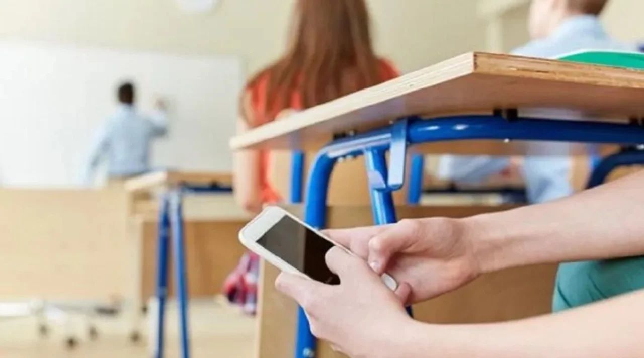 Niños usando celulares en un aula