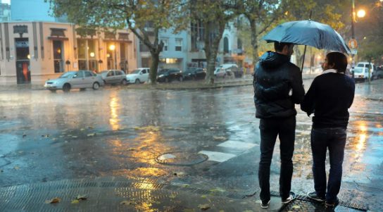 Personas con paraguas en una calle de Buenos Aires bajo lluvia