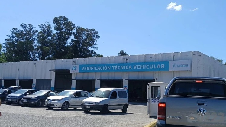 Taller de verificación técnica vehicular con un auto en un elevador