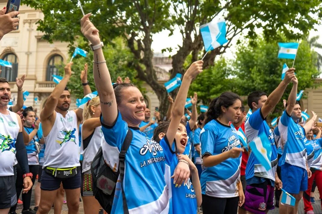 Corredores en una carrera rural con remeras celestes y blancas