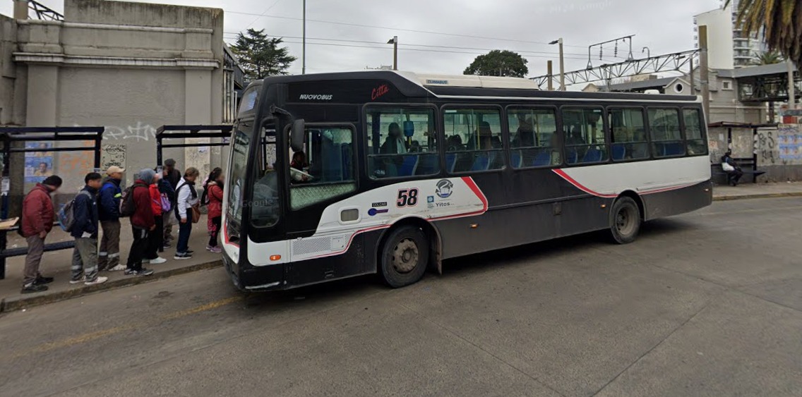 Colectivo circulando por una calle del conurbano bonaerense