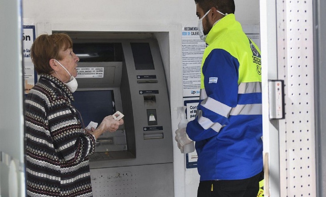 Personas mayores en una fila frente a una entidad bancaria