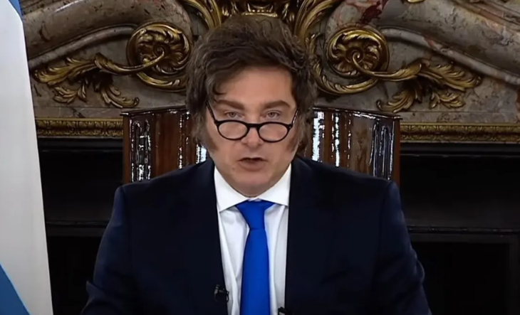 Javier Milei hablando en cadena nacional con la bandera argentina de fondo
