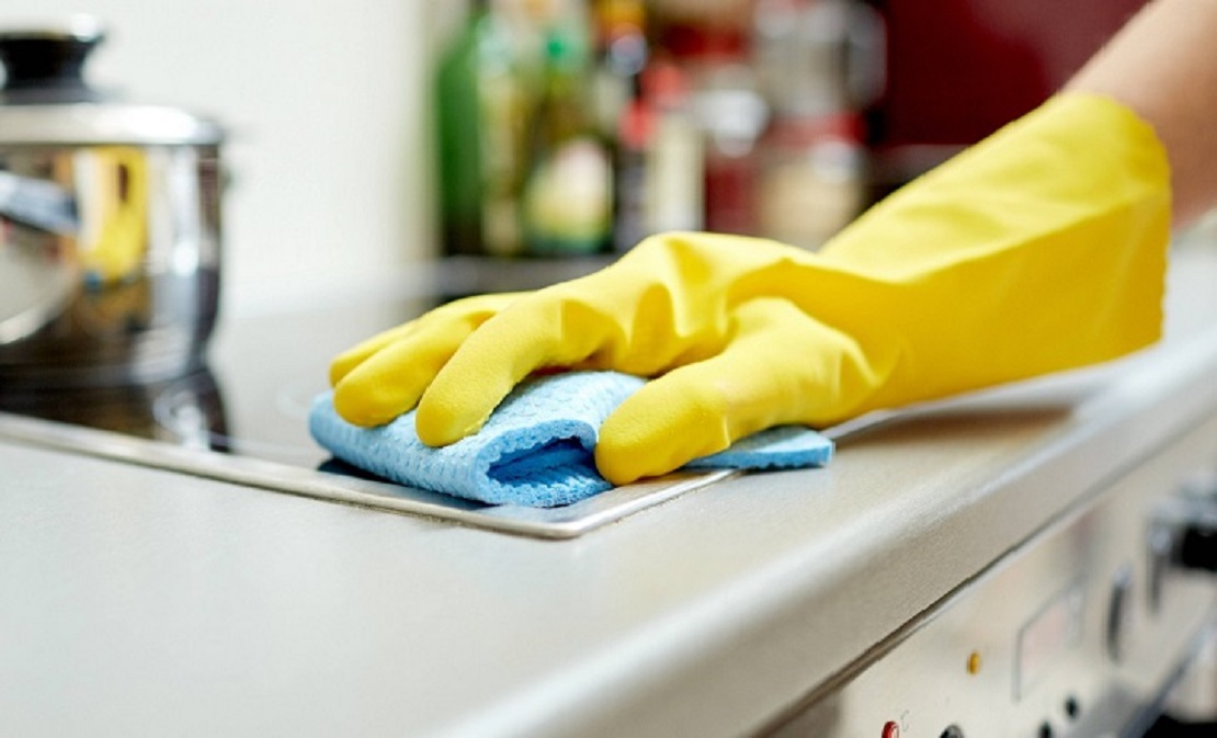 Empleada doméstica limpiando una mesa en un hogar